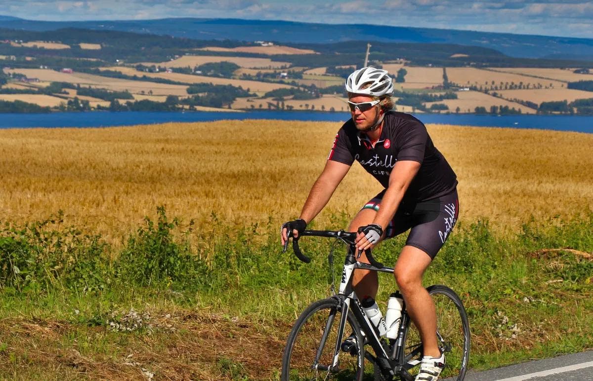 Syklist ved et åkerslandskap